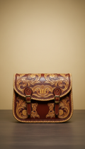 Tooled leather saddle bag with gilded accents